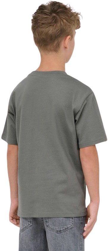 Jongen met blond haar draagt een effen donkergrijs T-shirt en spijkerbroek, van achteren gezien.