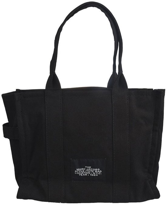 Zwarte canvas tas van Marc Jacobs met label met merknaam, type tas en jaar.
