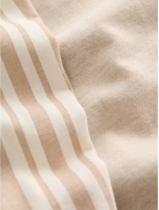 Beige stof en stof met verticale beige en witte strepen, close-up.