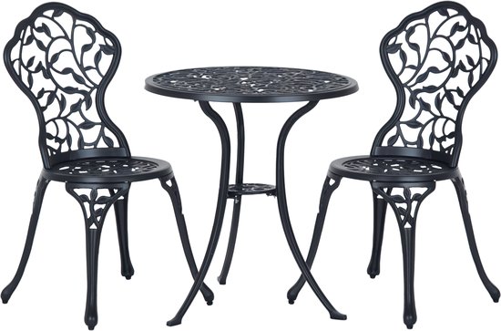 Zwart gietijzeren bistroset met rond tafelblad en twee stoelen, bladerenmotief op rugleuningen, op witte achtergrond.
