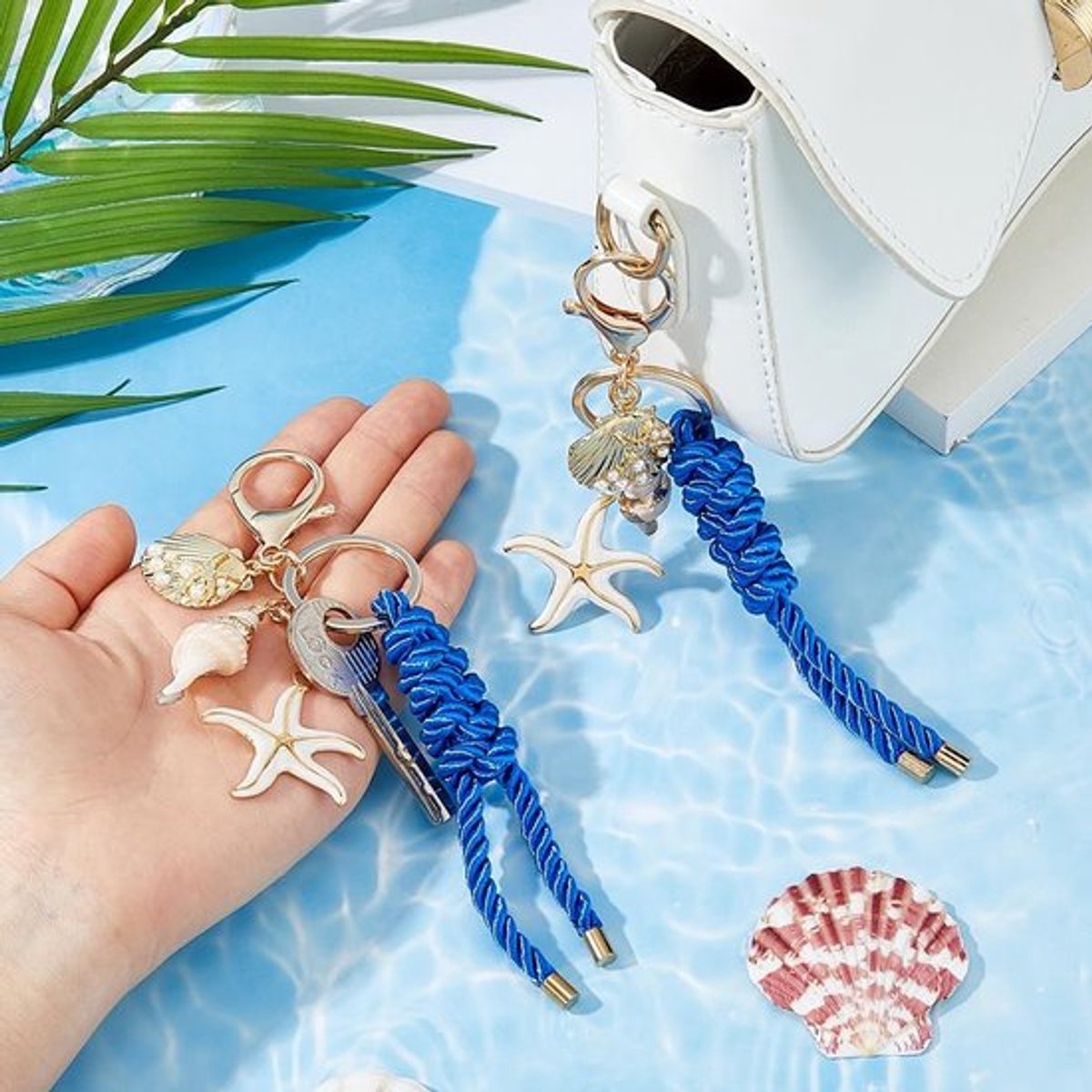 Sleutelhanger Gouden Zeester/Schelp - 2 Stuks - Strand Charms - Blauw Gevlochten Touw - Kuststijl Accessoires - 125 mm Lang - Tascharms