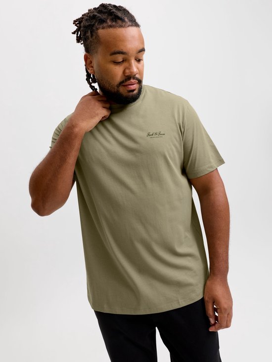 Man draagt olijfgroen T-shirt met 'Jack & Jones ARCHIVE SELECTION' logo. Houdt zijn nek vast.