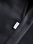 Close-up van zwarte stof met wit label met het JACK&JONES logo.