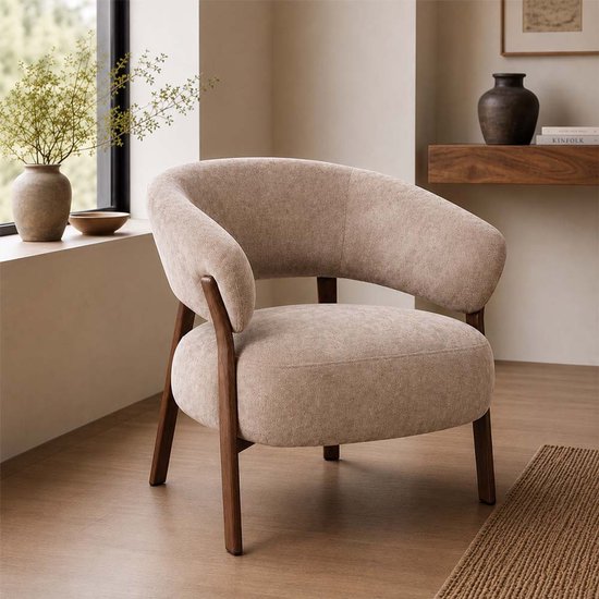 Taupe fauteuil met gebogen rugleuning en houten frame in een woonkamerinterieur.