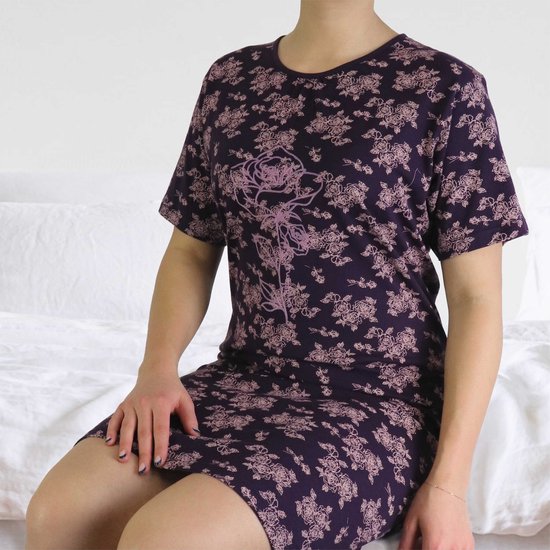 Model in een paars nachthemd met korte mouwen, bedrukt met roze rozen en een grote roos op de voorkant.