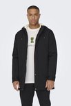 Man draagt zwarte parka met witte voering over een wit T-shirt met Minecraft Creeper-opdruk.