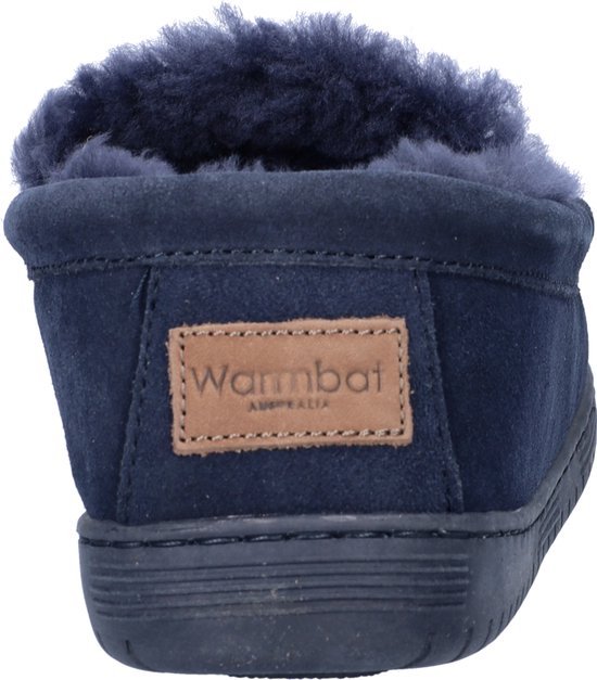 Achterkant van donkerblauwe suède pantoffel met lamsvel voering en bruin 'Warmbat' label.
