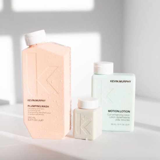 Drie producten van KEVIN.MURPHY op een witte achtergrond: PLUMPING.WASH, een kleine witte fles en MOTION.LOTION.