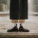 Donkerblauwe sokken met "De Wanderer above the Sea of Fog" van Friedrich, bij water.