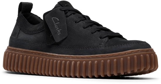 Zwarte sneaker met bruine plateauzool en Clarks label.