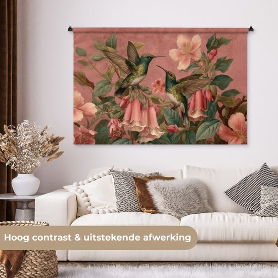 Wandkleed met roze achtergrond, kolibries vliegen tussen bloemen, boven een bank.