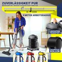 Vrouw met blauwe jas gebruikt een industriële stofzuiger met een telescoopsteel (83-153cm) en een werkradius van 9 meter.