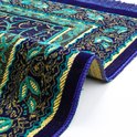 Partie détaillée d'un tapis de prière bleu foncé avec des motifs de feuilles bleus et dorés et une bordure jaune avec des franges.