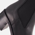 Zwarte leren Chelsea boot met elastische zijkanten en een blokhak.