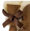 Detail van een bruin satijnen strikje op de achterkant van een cognackleurige UGG-laars met witte schapenwollen voering.