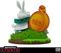 Witte konijn uit Alice in Wonderland met een grote gouden zakhorloge en groene struiken.