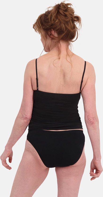 Model draagt van achteren een zwarte kanten top en bijpassende zwarte slip.