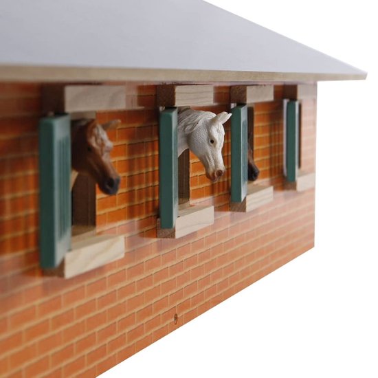 Houten paardenstal, close-up van paardenkoppen uit de ramen met groene luiken.