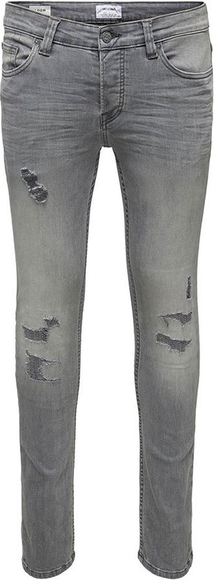 Grijze skinny jeans met scheuren op de dijen en knieën.