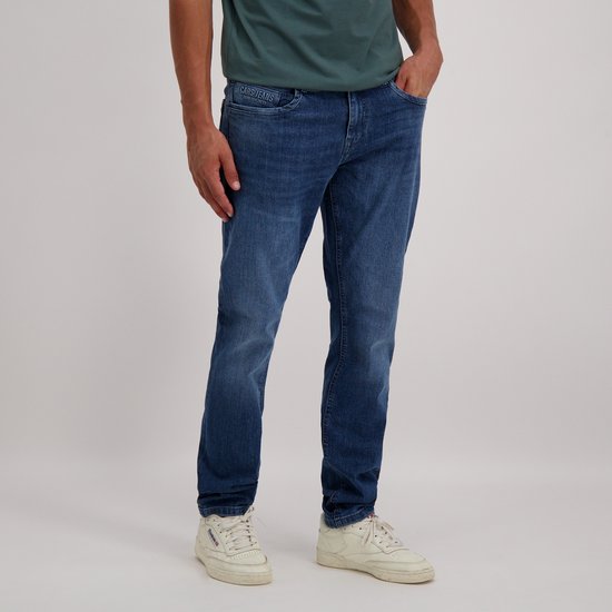 Man draagt een donkerblauwe jeans met lichte wassing en logo 'Cars Jeans' op de tailleband.
