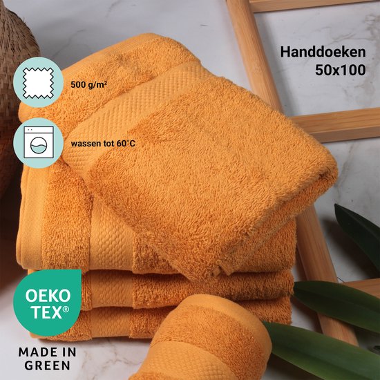 Stapel okergele handdoeken (50x100 cm) met een textuur van 500 g/m2. Wasbaar tot 60°C. OEKO-TEX gecertificeerd.