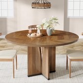 Ronde, houten eettafel met visgraatpatroon, omringd door beige stoelen en een vaas met bloemen.