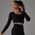 Model in zwart, nauwsluitend longsleeve crop top met vierkante halslijn.