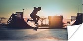 Poster Een jongen doet een stunt met zijn skateboard tijdens de zonsondergang - 150x75 cm