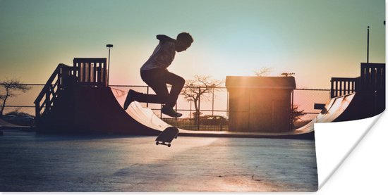 Poster - Een jongen doet een stunt met zijn skateboard tijdens de zonsondergang