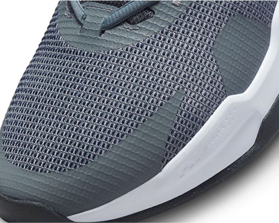 Close-up van de neus van een grijze Nike sneaker met mesh textuur en witte zool met swoosh.