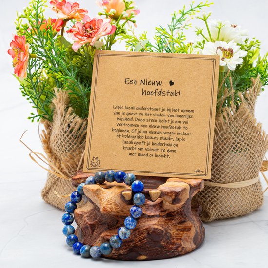 Lapis lazuli armband op een houten display, met twee met jute omwikkelde bosjes bloemen en een kaart.
