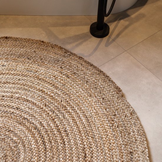 Rond vloerkleed in naturel jute met een gevlochten patroon.