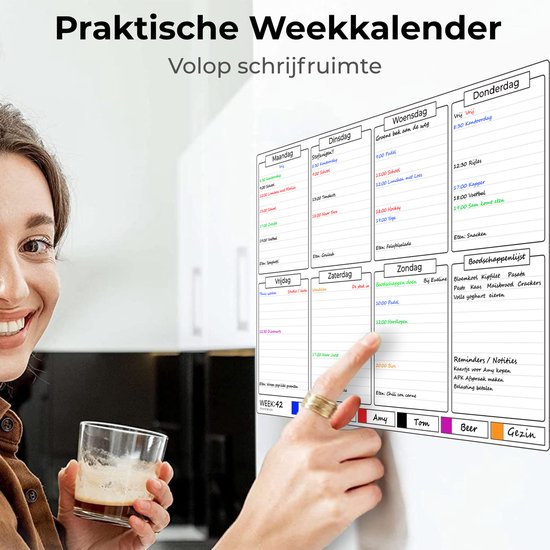 Een vrouw met een drankje lacht terwijl ze naar de magnetische weekplanner op de koelkast kijkt. Planbord met secties voor dagen, boodschappenlijst en notities.