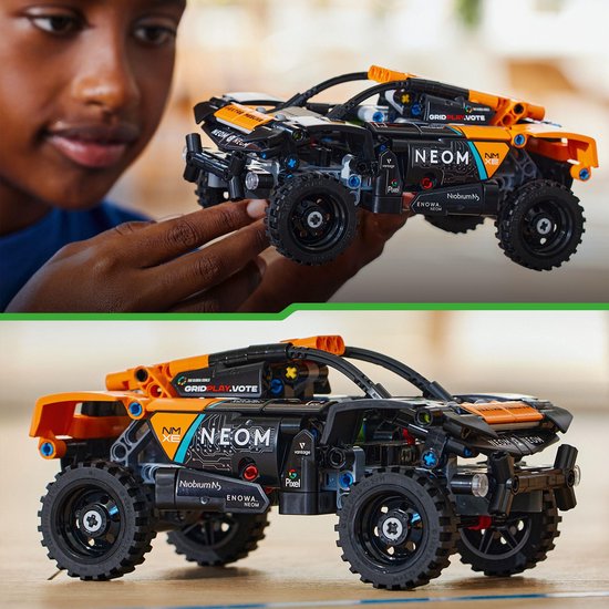 Jongen die een zwarte en oranje LEGO Technic auto vasthoudt. De auto is gedetailleerd met sponsors.