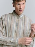 Close-up van een beige linnen mix blouse met verticale strepen in beige, bruin, blauw en grijs. De blouse heeft knopen van houtkleurige stof.