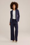Dames donkerblauwe blazer met witte top, staand model.