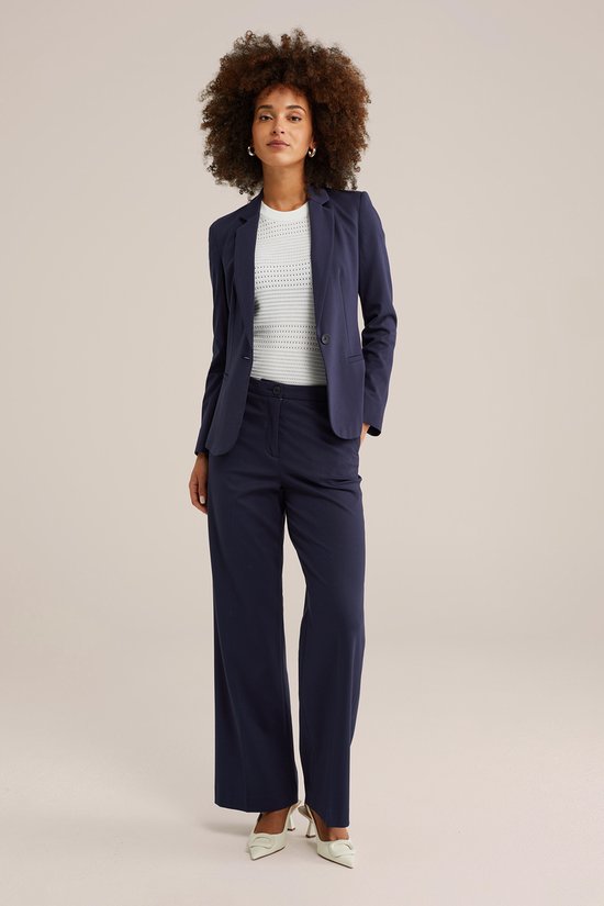 Dames donkerblauwe blazer met witte top, staand model.