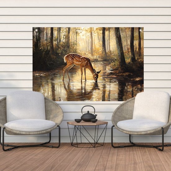 Een tuinposter met een schilderij van een hert dat uit een bosvijver drinkt, hangt tussen twee stoelen op een houten terras.