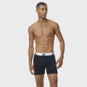 Man met zwarte boxershorts met brede, witte Adidas-band met logo's.
