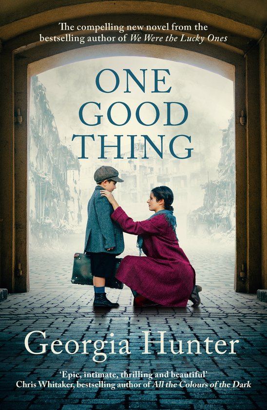 Boekcover met de titel 'ONE GOOD THING' door Georgia Hunter. Een jongen in een pet en jas staat met een koffer, een vrouw knielt bij hem. Achtergrond van verwoesting.