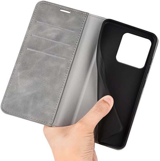 Hand toont een grijs telefoonhoesje met drie kaartsleuven en een zwarte houder voor de telefoon.