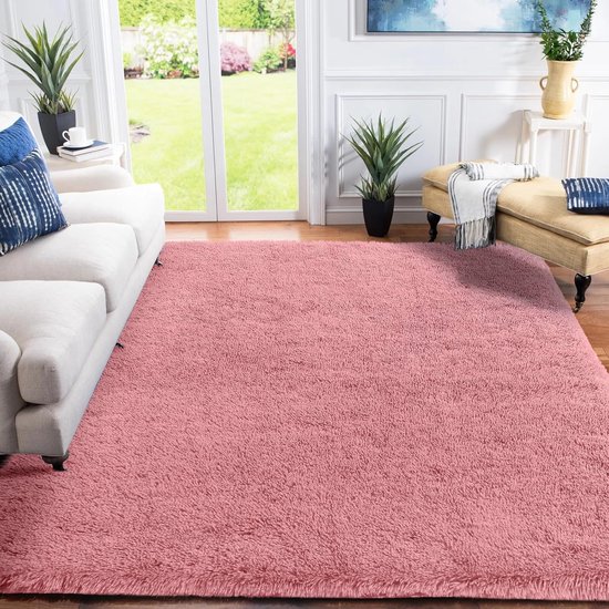 Tapis rose à poils longs dans un salon avec un canapé blanc et une méridienne jaune.