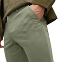 Man met hand in zak van lichtgroene chino.