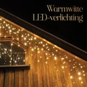 Warme witte LED-verlichting hangend aan de dakrand van een houten gebouw.