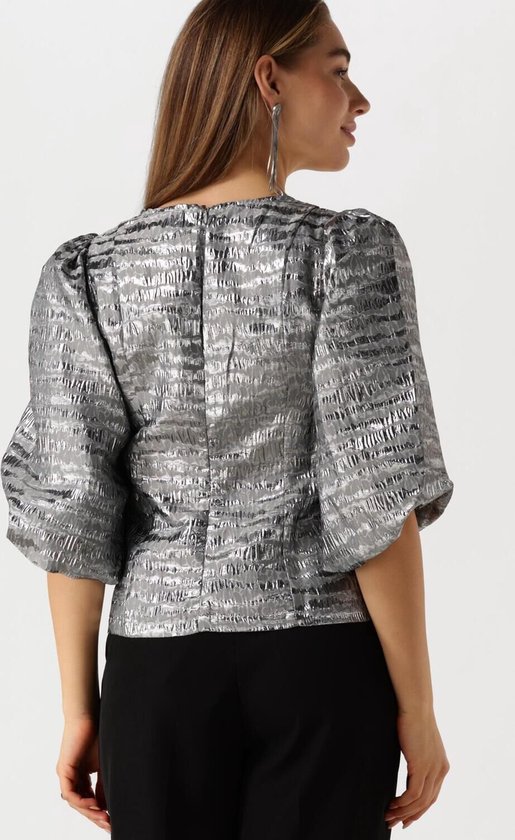 Model draagt zilveren blouse met pofmouwen en V-hals, van achteren gezien.