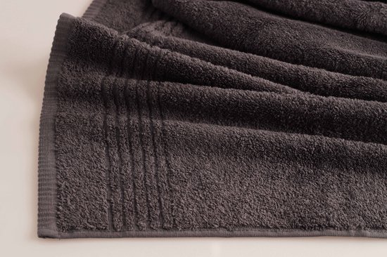 Détail d'une serviette gris foncé avec un bord côtelé et une texture douce.