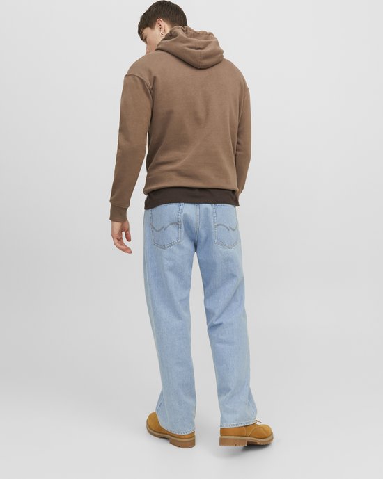Man in een lichtblauwe jeans en bruine hoodie, gezien vanaf de achterkant.
