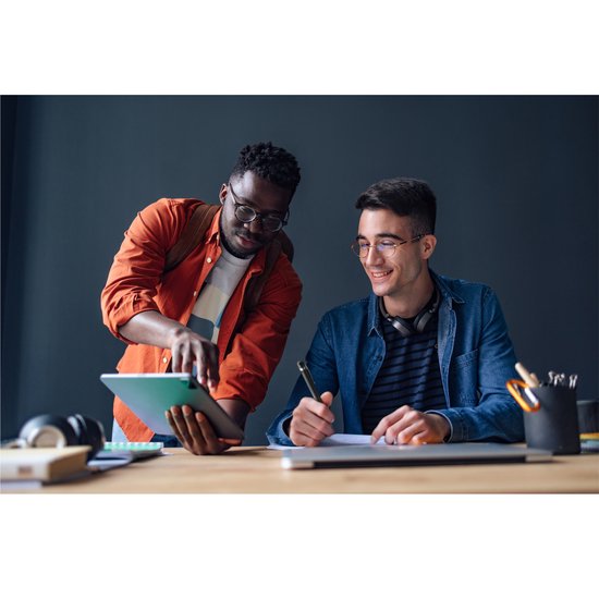 Twee studenten werken samen aan een tablet, één schrijft met een pen.