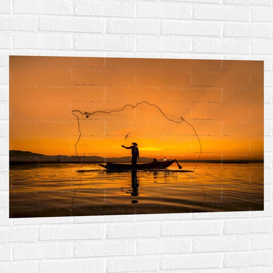 WallClassics - Muursticker - Silhouet van Visser op Bootje bij Oranjekleurige Lucht - 105x70 cm Foto op Muursticker