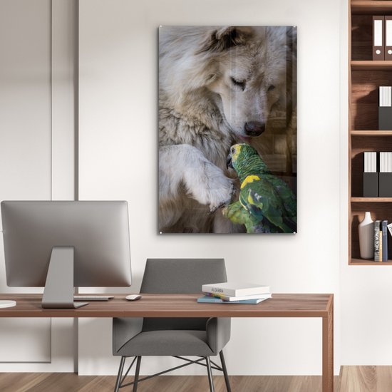 Een witte hond en een groene papegaai op een glasafbeelding boven een bureau.